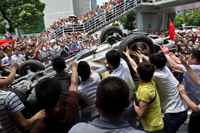 Người biểu tình xúm vào lật ngửa ô-tô Nhật